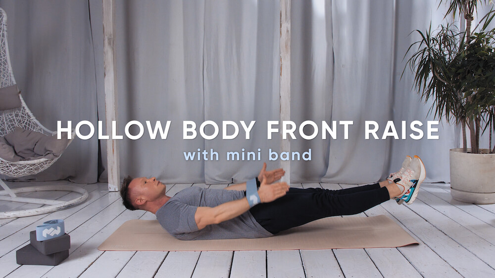 Zdjęcie ćwiczenia Hollow body front raise with mini band